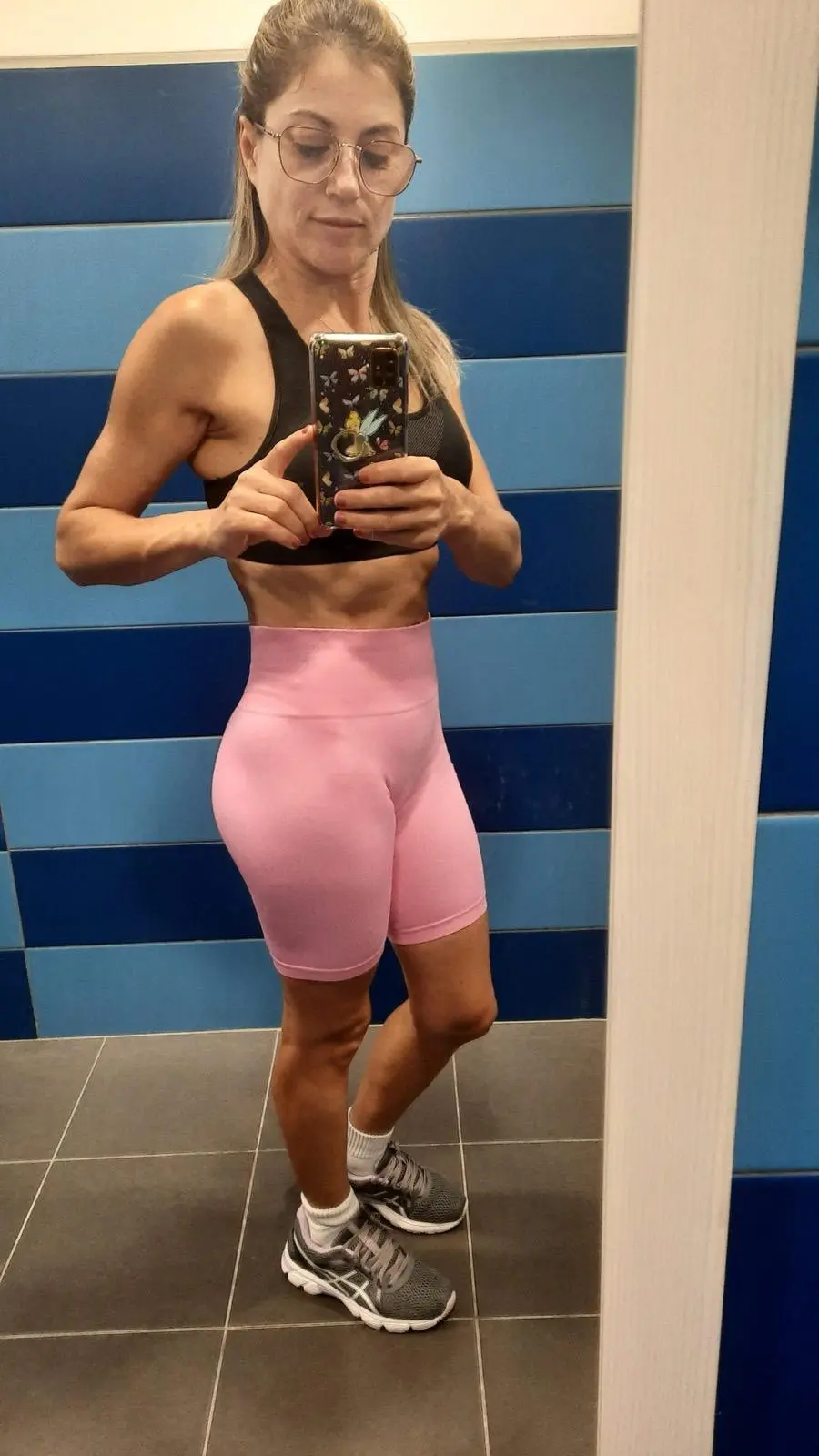 Fotografia dramática de alto contraste mostrando recomposição corporal, com mais massa magra e menos gordura sob iluminação intensa de ginásio. Antes.